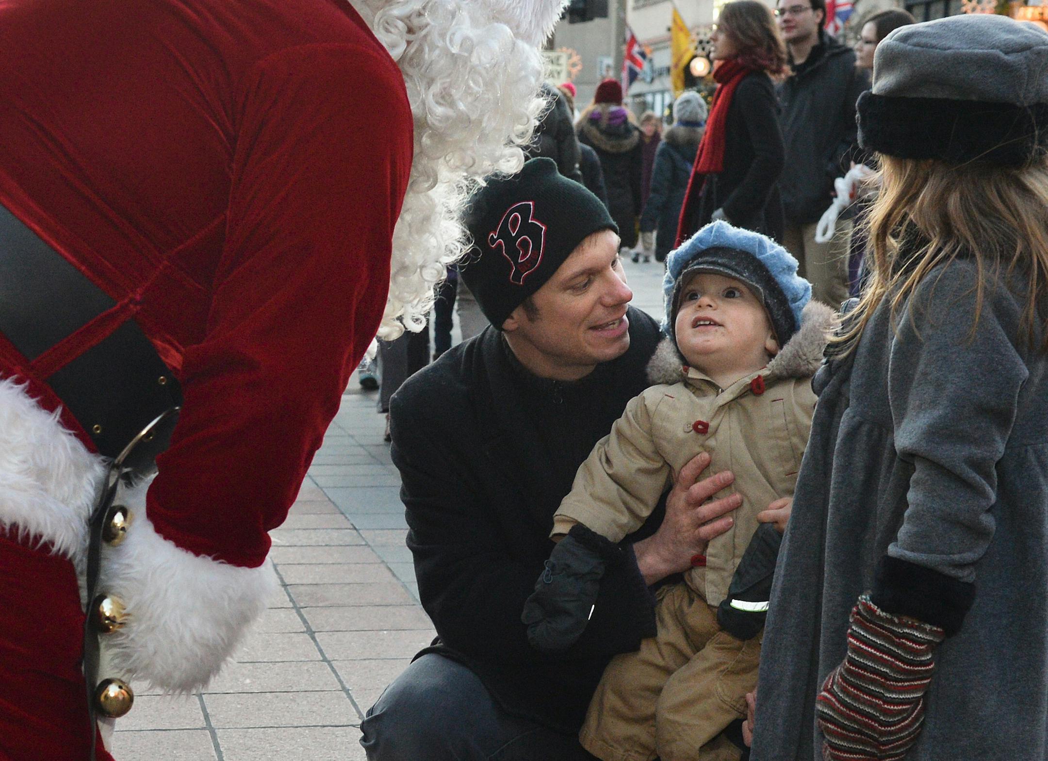 Simon Wagner, 1, gets an up close look at the Big Guy himself with his father, Mark, and sister Zoe, 6, at the Holidazzle Village on Nicolet Mall. ] (SPECIAL TO THE STAR TRIBUNE/BRE McGEE) **Simon Wagner (center, 1-year-old), Mark Wagner (left, holding Simon), Zoe Wagner )right, 6-years-old), Santa Clause (red suit)
