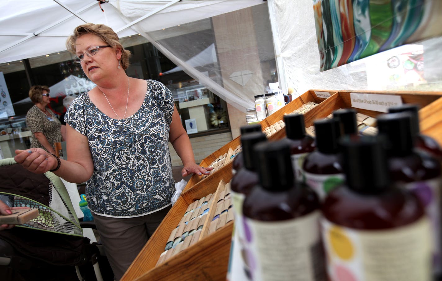 Amy Brooks of "Bubbles by Brooks" waited for shoppers to stop at her tent Thursday June 28, 2012 in Rochester, MN. Rooks of Rochester , sells soaps that are designed to reduced skin irritation to cancer patients as they go through therapy.] Jerry Holt/ STAR TRIBUNE.COM)