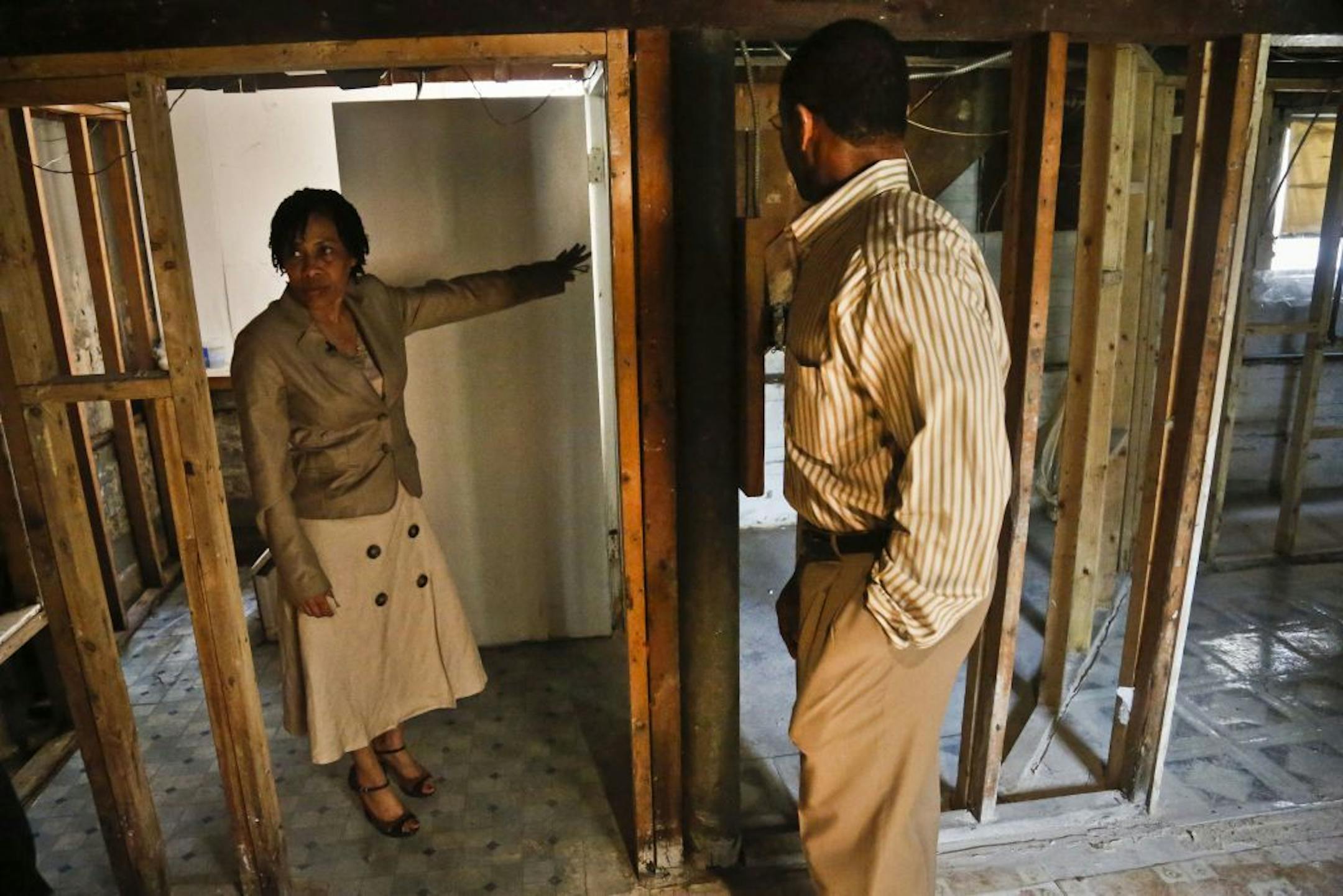 In this May 7, 2013 photo, Yvonne Rankine, left, and her husband, Rev. Trevor Rankine, tour the basement of their home in New York. The home is faced with a growing mold problem, a development they say resulted in the aftermath of Sandy storm damage.