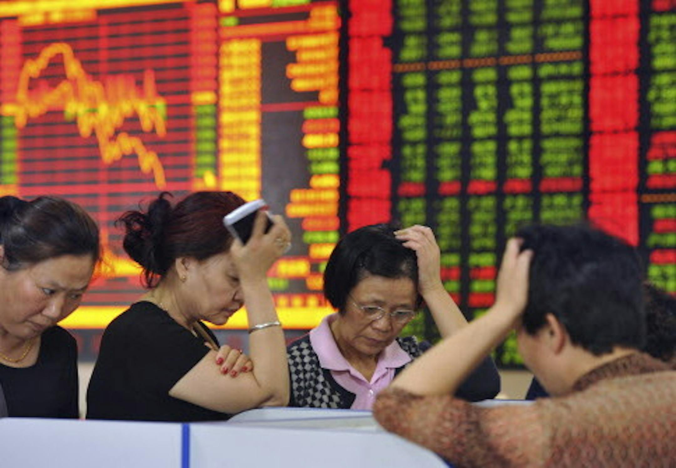 In this photo taken May 28, 2015, Chinese stock investors react as prices fall at a brokerage house in Fuyang in central China's Anhui province. China's latest stock market boom began after the state press said last summer stocks were cheap. Investors took that to mean Beijing wanted prices to rise - and might prop up markets if needed. The benchmark Shanghai Composite Index has soared 140 percent over the past six months, though it has suffered stomach-churning drops along the way, most recentl