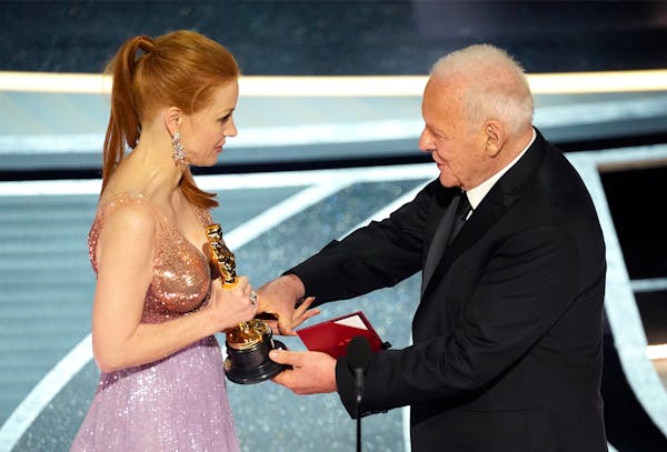 Anthony Hopkins, right, presents Jessica Chastain with the award for best performance by an actress in a leading role for "The Eyes of Tammy Faye" at 