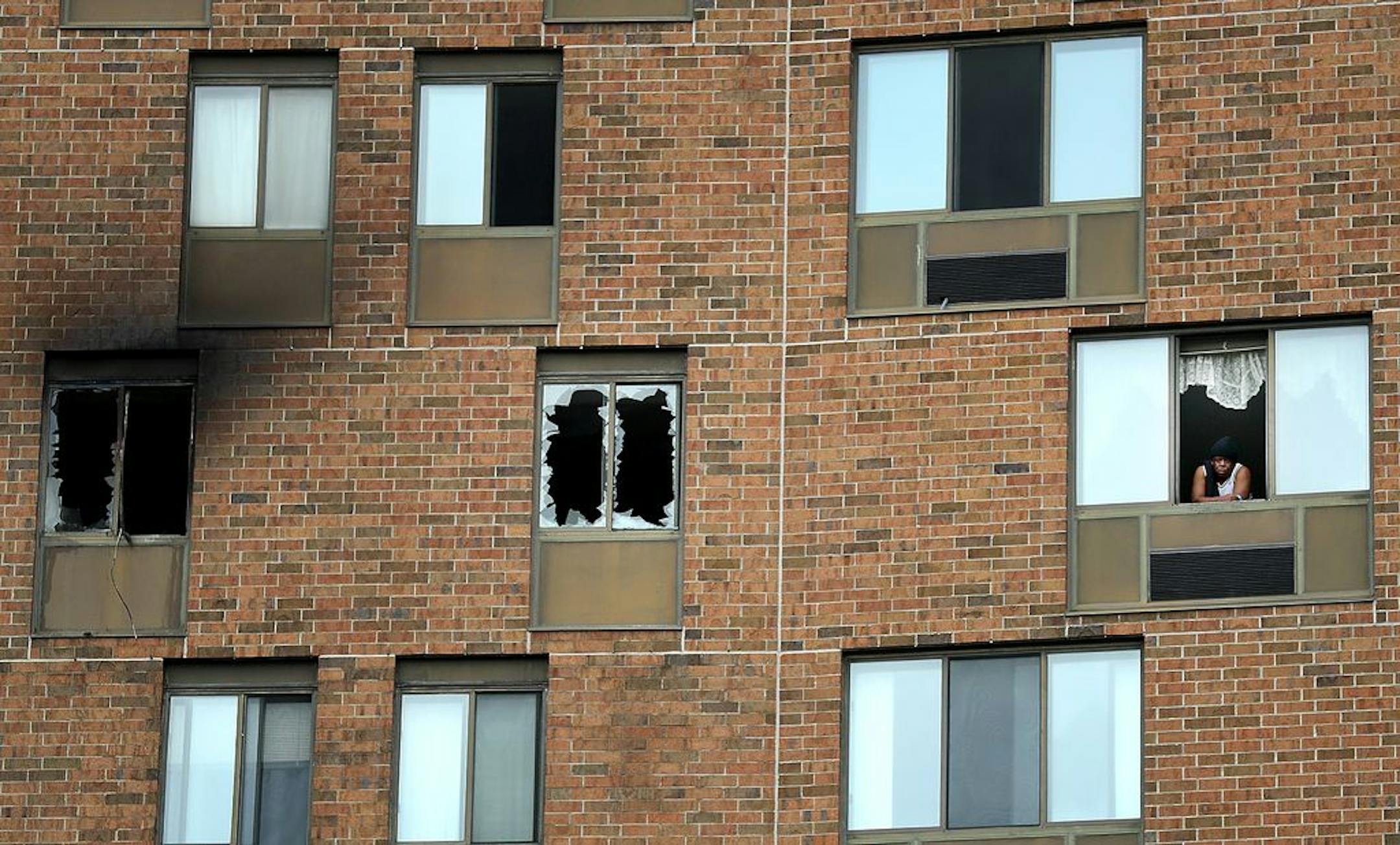 A person peers out a window on the 11th floor where an overnight fire in the a high-rise Wilder Park Condominiums in St. Paul sent one person to the hospital and about 100 residents were evacuated while the fire was fought and seen Tuesday, May 19, 2020, St. Paul, MN. More than 60 personnel fought the fire in the 16 floor high-rise.