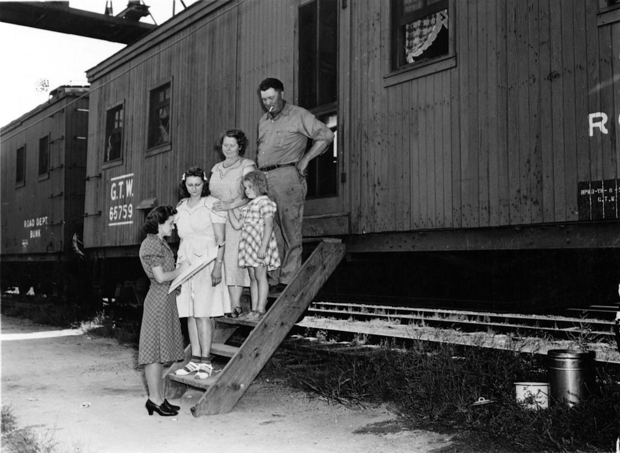 In this photo provided by the National Archives at College Park, an enumerator, left, interviews a family outside a rail car for the 1940 Census.