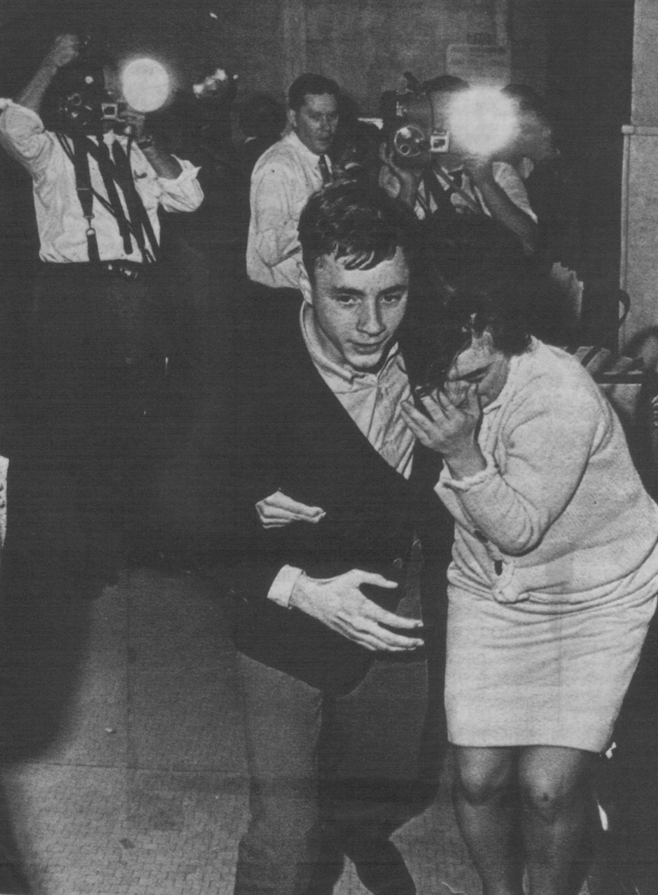 December 7, 1963 An Unidentified woman spectator of the Thompson trial was led down a hallway of the Courthouse Fri-day night after the guilty verdict was read. The woman's unidentified male companion led her out of the building as she sobbed and screamed, "No, no, no!" She could not believe that the jury found Thompson guilty of first degree murder. December 6, 1963 United Press International