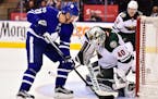 Minnesota Wild goalie Devan Dubnyk (40) makes a save on Toronto Maple Leafs center Dominic Moore (20) during the second period of an NHL hockey game W