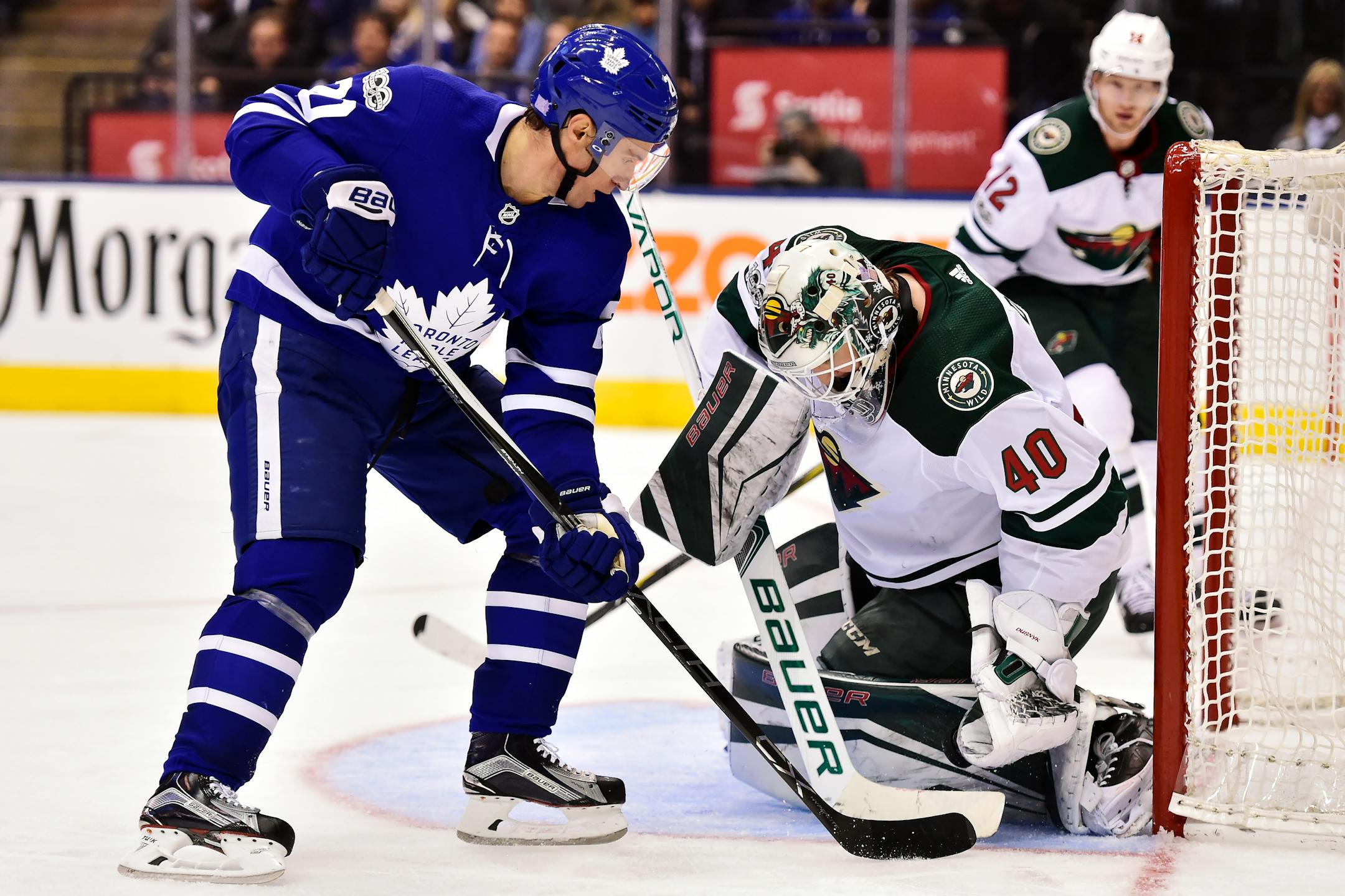 Minnesota Wild goalie Devan Dubnyk (40) makes a save on Toronto Maple Leafs center Dominic Moore (20) during the second period of an NHL hockey game Wednesday, Nov. 8, 2017, in Toronto. (Frank Gunn/The Canadian Press via AP)
