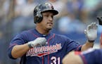 Minnesota Twins' Oswaldo Arcia, left, is high-fived by teammates after hitting a home run in the ninth inning of a baseball game against the Atlanta B