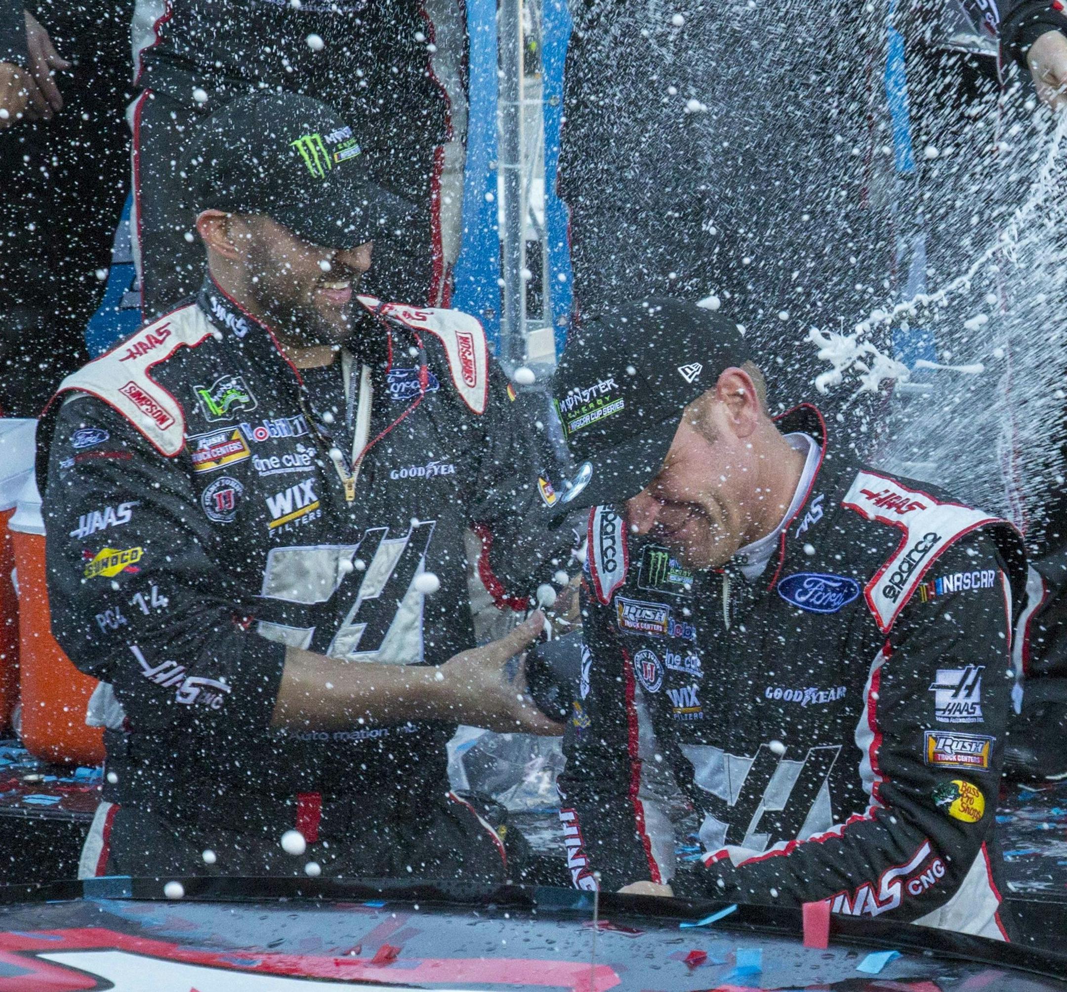 Clint Bowyer, right, celebrates with his crew after winning a NASCAR Cup Series auto race at Martinsville Speedway in Martinsville, Va., Monday, March 26, 2018. (AP Photo/Matt Bell)