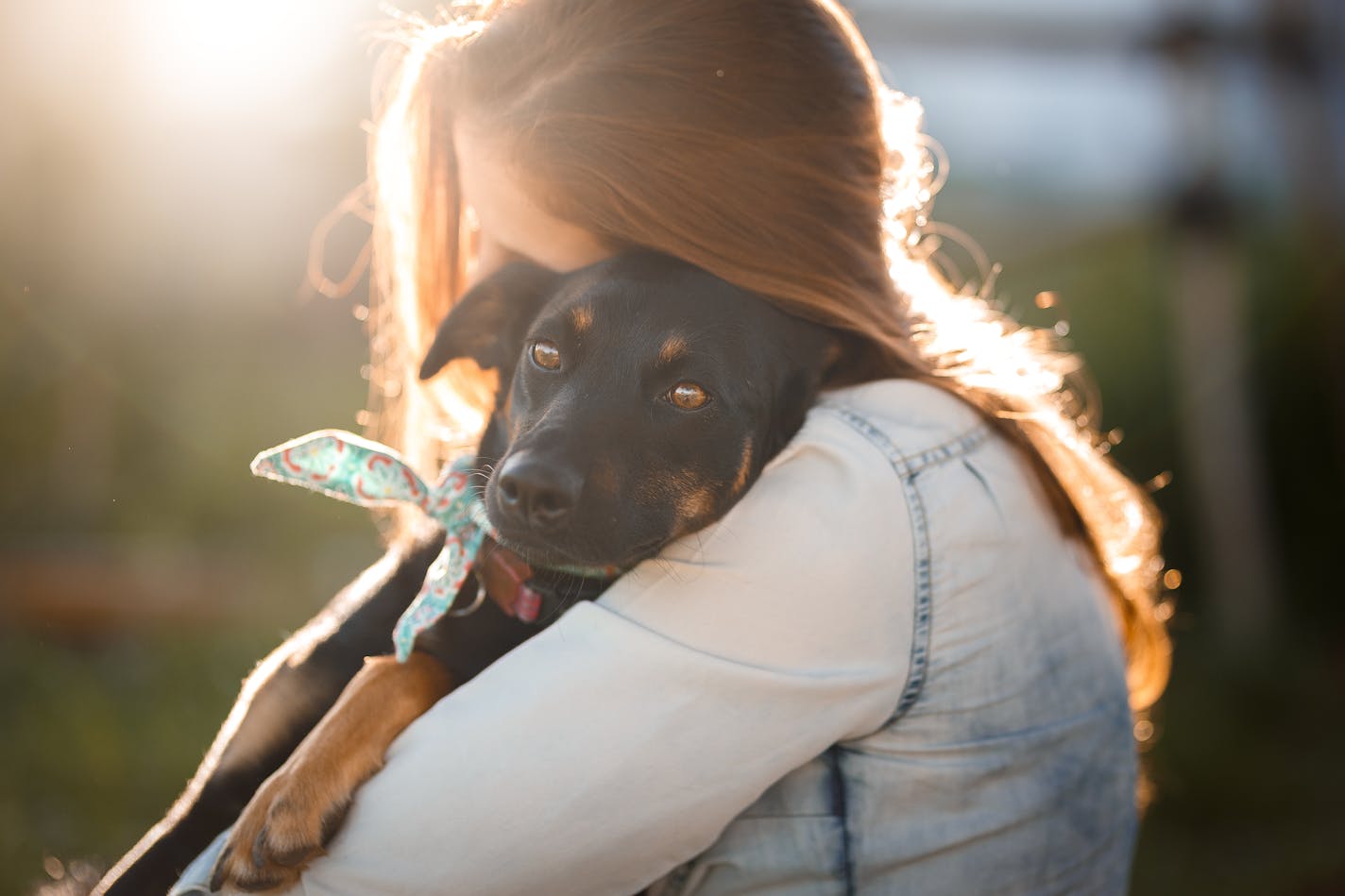 Girl hugging her cute black mutt dog