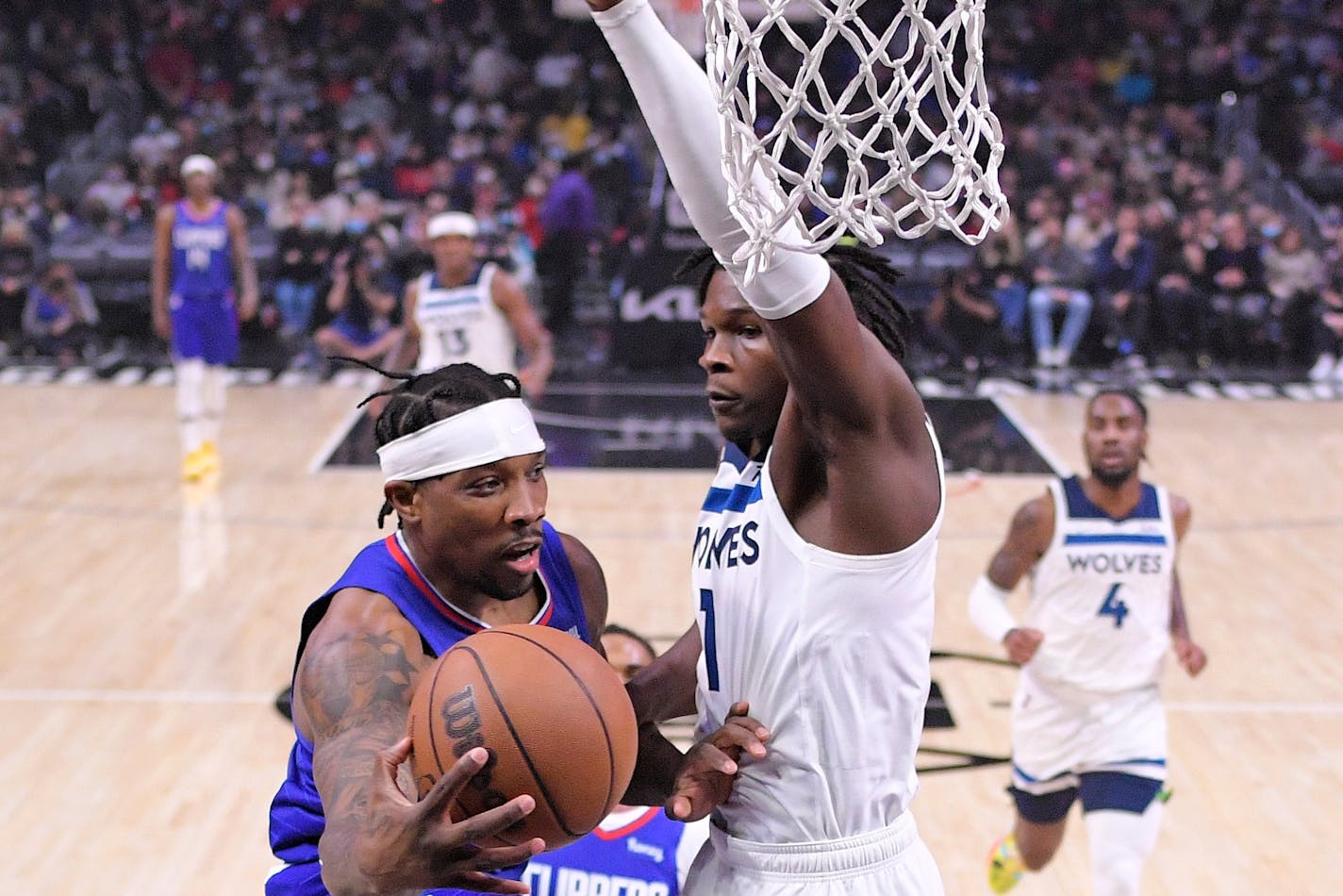 Los Angeles Clippers guard Eric Bledsoe, left, passes the ball as Minnesota Timberwolves forward Anthony Edwards defends during the first half of an NBA basketball game Monday, Jan. 3, 2022, in Los Angeles. (AP Photo/Mark J. Terrill)