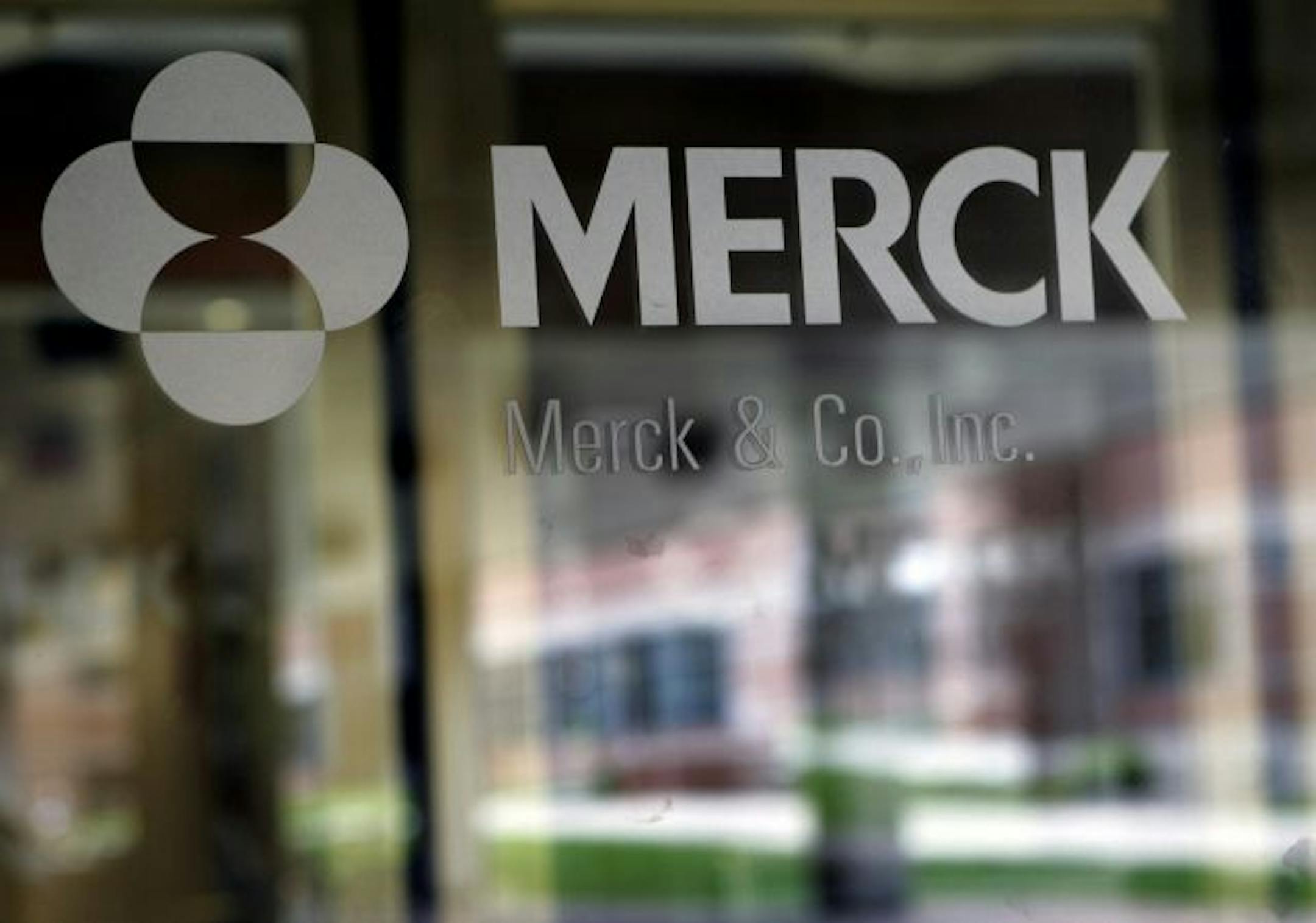 In this May 22, 2008 file photo, the company logo is seen on the doors of a building at Merck & Co. headquarters in Whitehouse Station, N.J. Drugmaker Merck & Co. on Tuesday, July 21, 2009, posted a 12 percent drop in second-quarter profit, due to lower sales of its cholesterol drugs and several vaccines, but still beat Wall Street's conservative expectations.