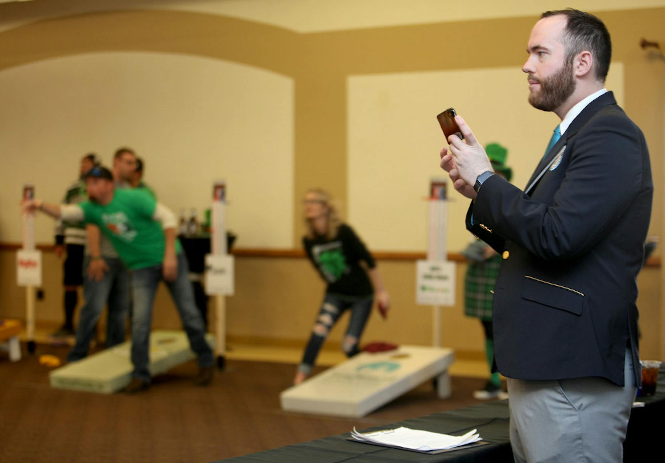 Adjudicator Mike Marcotte, of Minneapolis, MN, observes and "collects official evidence" with his cell phone before his announcement at the annual Cabin Fever Bean Bag Tournament that a Guinness World Record was set as the largest cornhole tournament Saturday, March 16, 2019 at the Rochester International Event Center in Rochester, MN. More than 380 participated and raised funds supporting cancer research. "There are less than 100 of us in the world, it's a pretty cool job," said Marcotte, who i