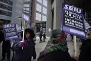 At the Securian Center in downtown St. Paul, several dozen janitors from the SEIU protested their wages .