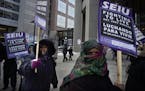 At the Securian Center in downtown St. Paul, several dozen janitors from the SEIU protested their wages .