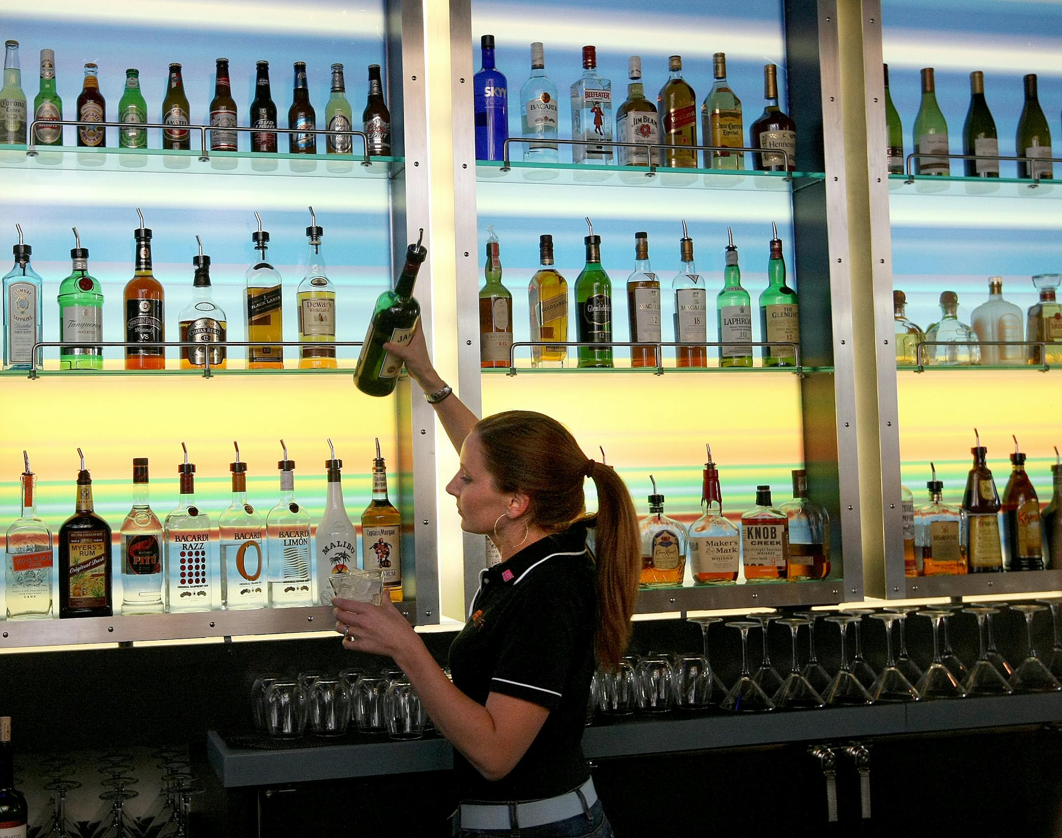 Bartender Tyrne Dixon gets a bottle of Jameson down from the back bar at the aloft hotel bar.