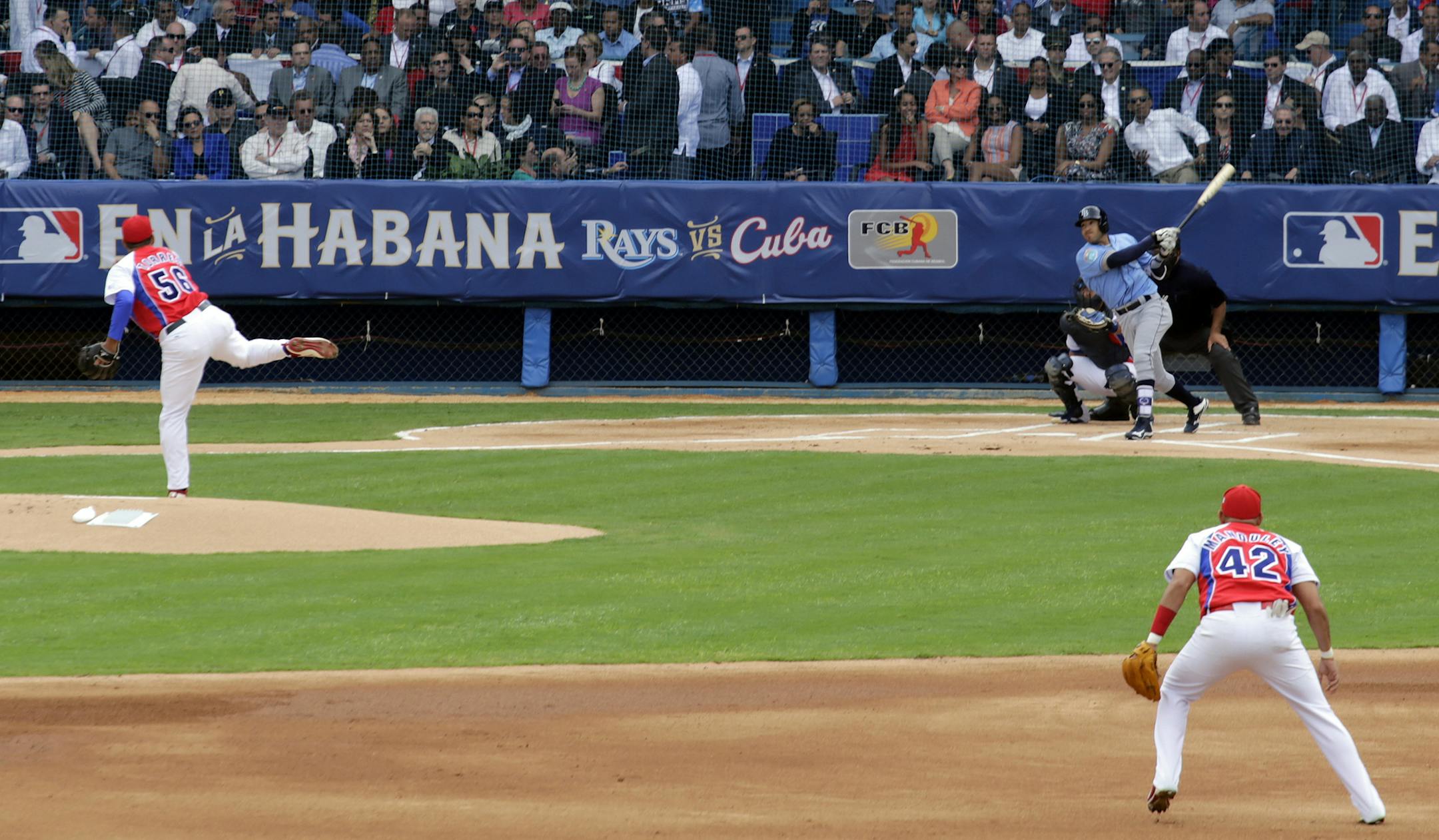 Tampa Bay Rays batman bats the ball as Presidents Obama and Castro watch during a baseball match between the Tampa Bay Rays and Cuba in Havana, Cuba, Tuesday March 22, 2016. The crowd roared as U.S. President Barack Obama and Cuban President Raul Castro entered the stadium and walked toward their seats in the VIP section behind home plate. It's the first game featuring an MLB team in Cuba since the Baltimore Orioles played in the country in 1999. (AP Photo/Ramon Espinosa) ORG XMIT: MIN2016032217