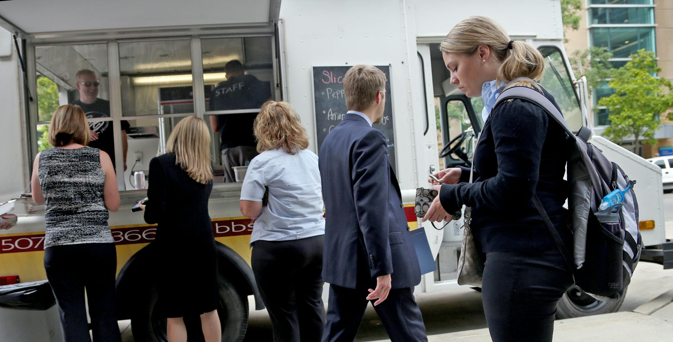 People lined up for food at the BB’s Pizzeria food truck last June in Rochester. The rogue food truck helped spur a food truck debate that led to the city passing a law this week allowing food trucks in a zone downtown.
