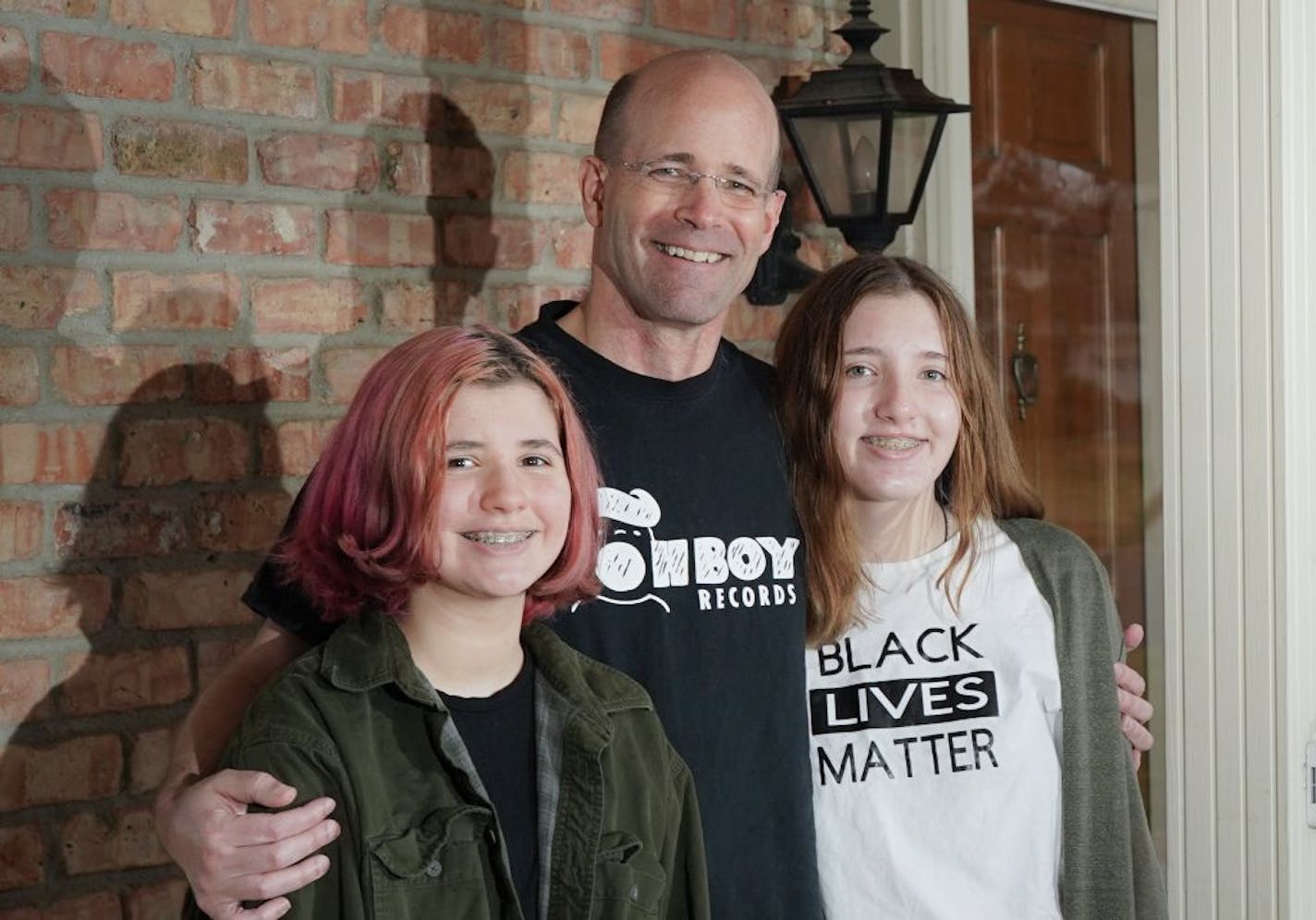 Rich Radke with daughters Clara, 13, left, and Ann, 14. The sisters have their own nonprofit, Bound to Be, and have collected and donated about 14,000 books.