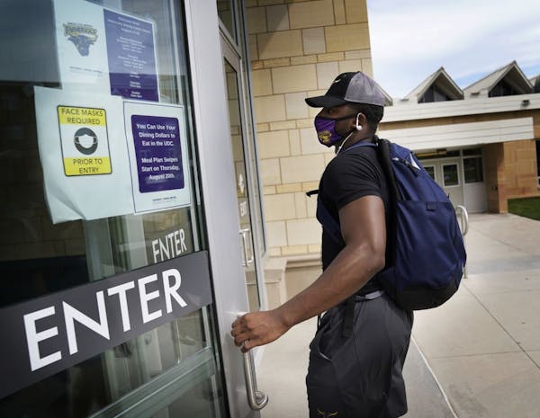 Students began moving into dormitories at Minnesota State University-Mankato Thursday where signs on campus reminded students to wear masks to fight t