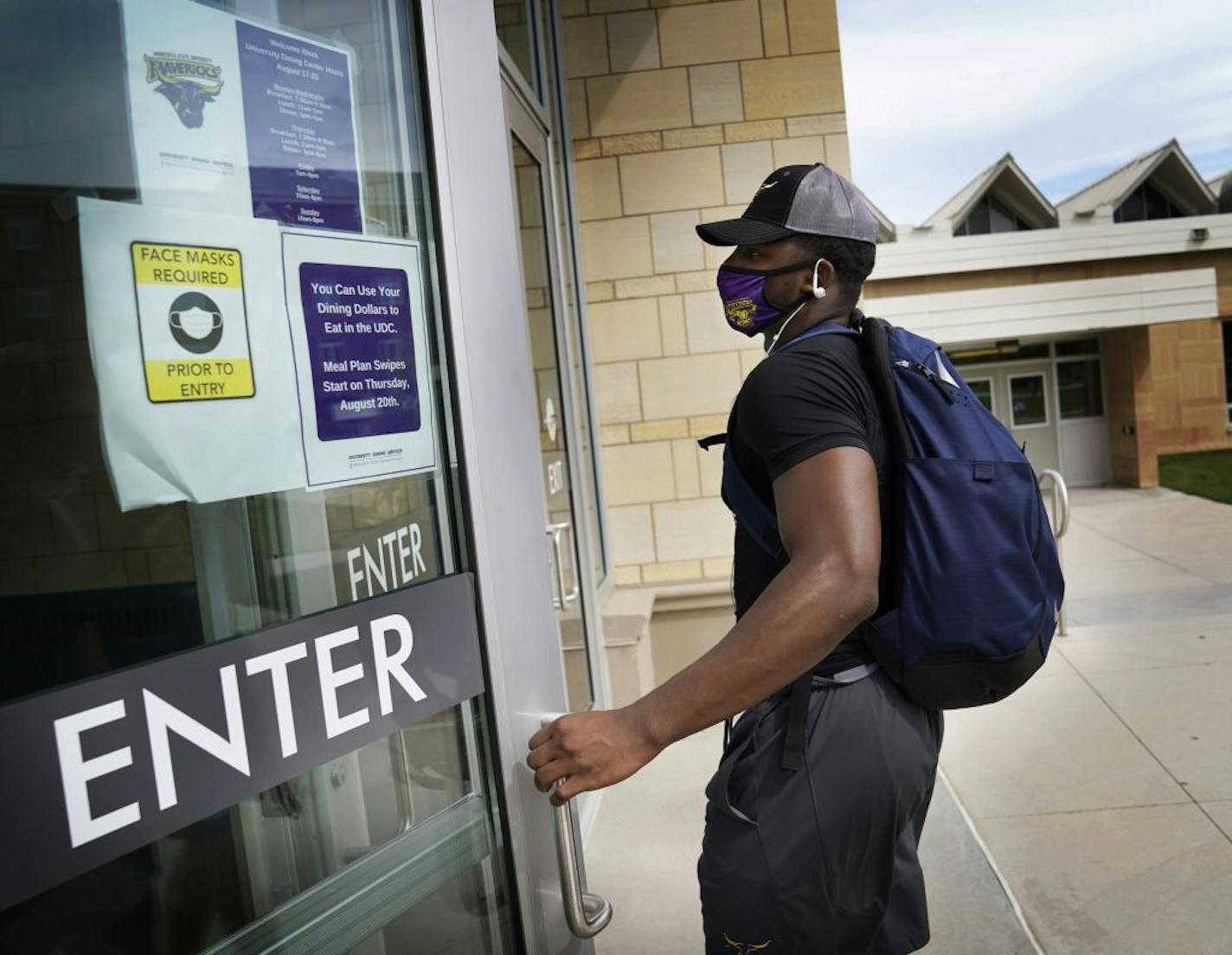 Students began moving into dormitories at Minnesota State University-Mankato Thursday where signs on campus reminded students to wear masks to fight the Coronavirus, where freshman Dexter Stigall of Chicago wore a mask to enter dining services.