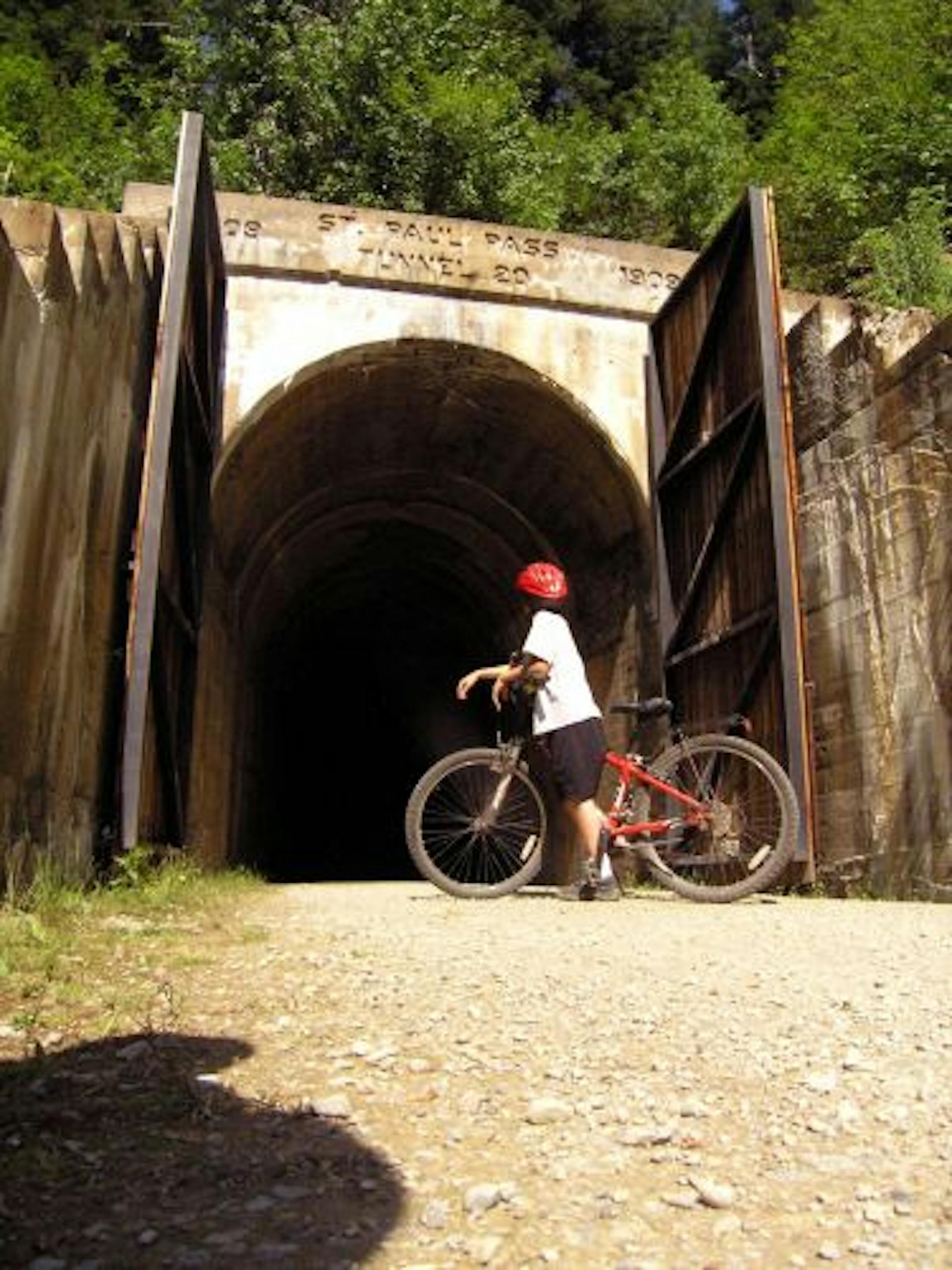 A biker pauses before entering the St. Paul Pass, a 1.66-mile tunnel that burrows under the Montana/Idaho state line. It is part of the Route of the Hiawatha bike trail.