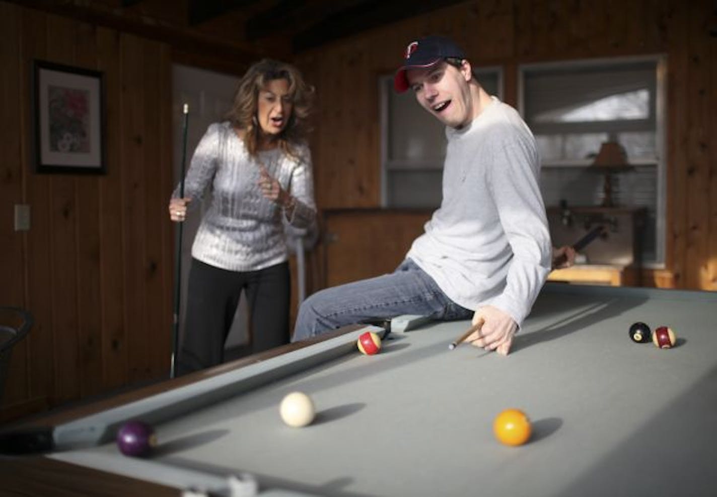 Michele Boston, playing pool here with Joseph Olson at Lillian's, and her husband, Jeff, own a company that runs 43 group homes in the Twin Cities.