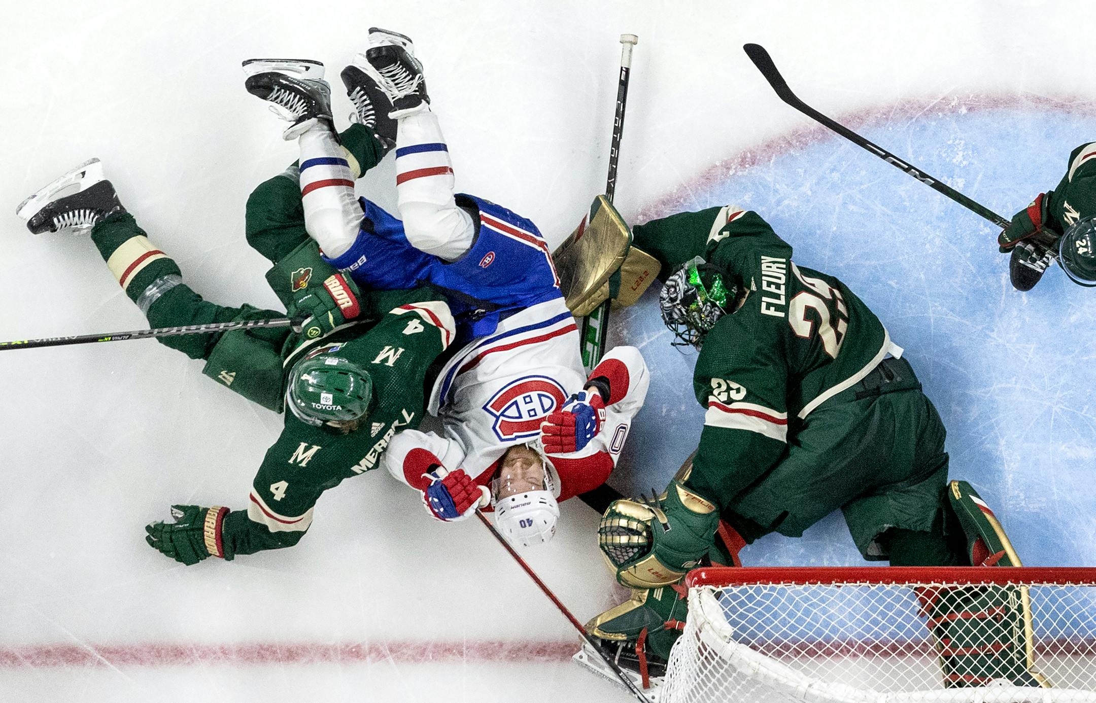 Montreal's Joel Armia (40) got tangled up with Jon Merrill (4) and goalie Marc-Andre Fleury (29) of the Wild in the second period.