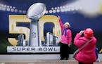 Angie Bagares poses for a photo Wednesday in front of a Super Bowl 50 sign at Super Bowl City in San Francisco.