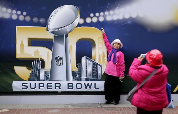 Angie Bagares poses for a photo Wednesday in front of a Super Bowl 50 sign at Super Bowl City in San Francisco.