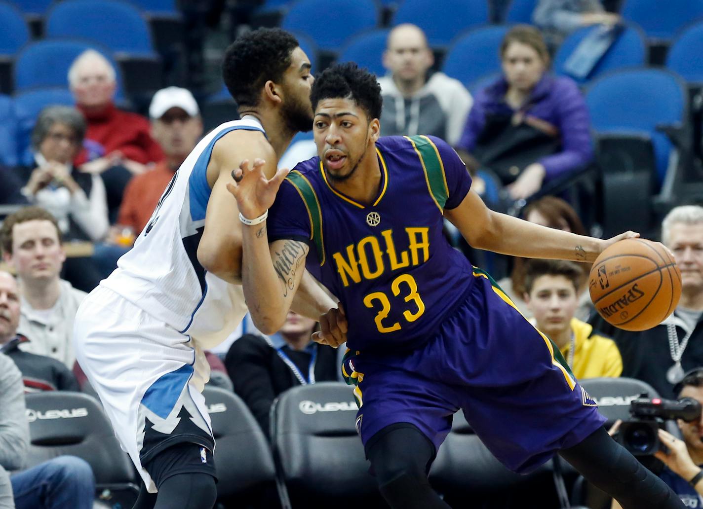 New Orleans Pelicans' Anthony Davis, right, drives around Minnesota Timberwolves' Karl-Anthony Towns in the first quarter of an NBA basketball game, Monday, Feb. 8, 2016, in Minneapolis. (AP Photo/Jim Mone)