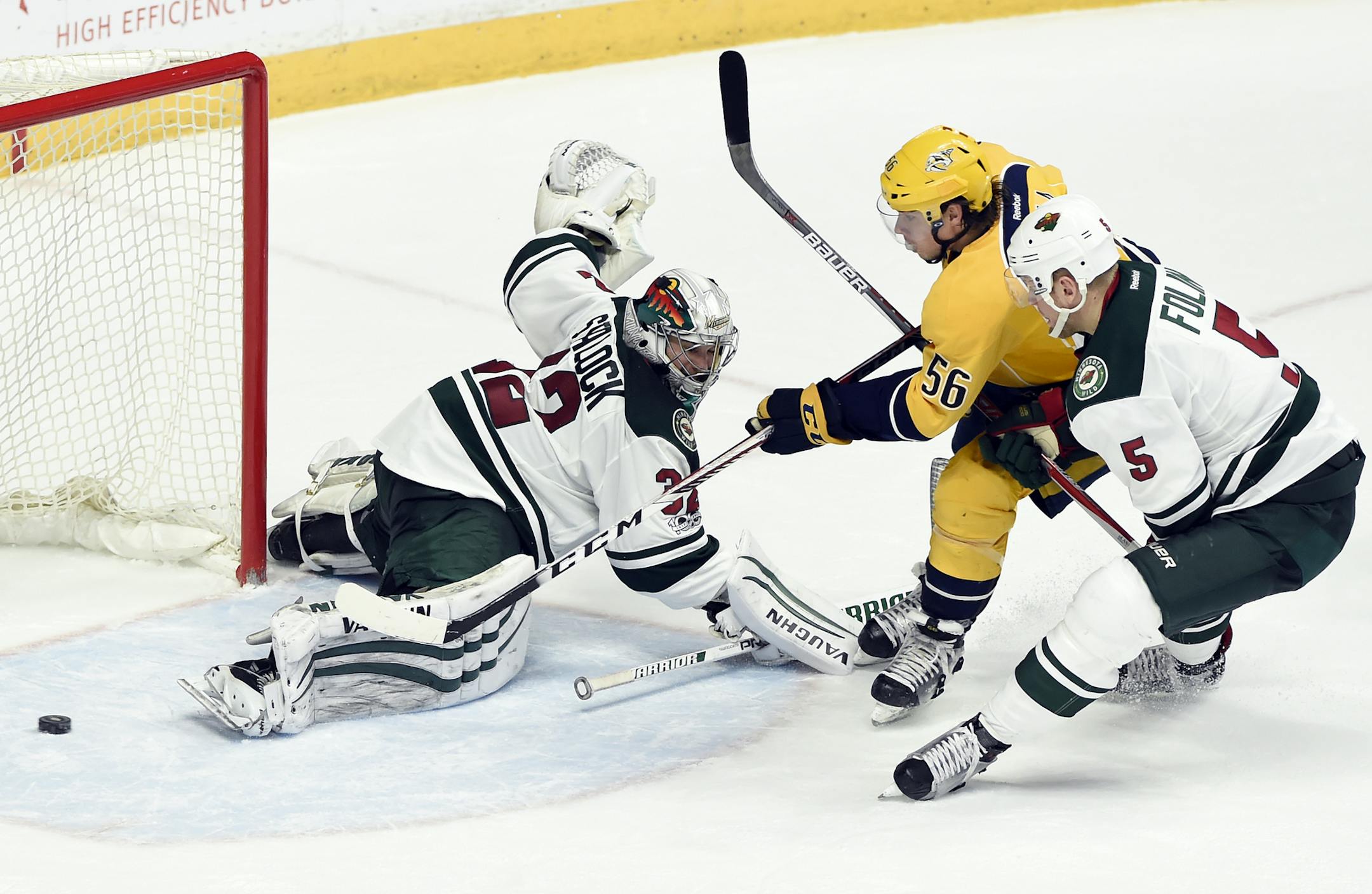 Nashville Predators left wing Kevin Fiala (56), of Czech Republic, scores a goal past Minnesota Wild goalie Alex Stalock (32) as defenseman Christian Folin (5), of Sweden, defends during the second period of an NHL hockey game Saturday, April 1, 2017, in Nashville, Tenn. (AP Photo/Mark Zaleski)