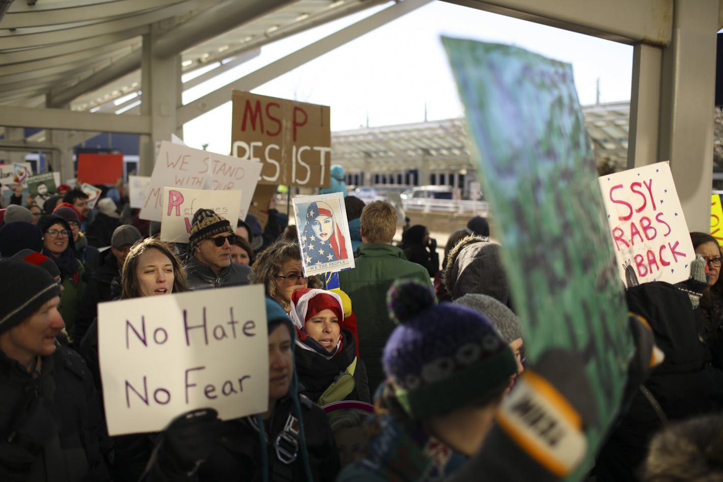 Demonstrators marched and chanted across the street from Terminal 1 Sunday afternoon shortly before taking the protest inside.