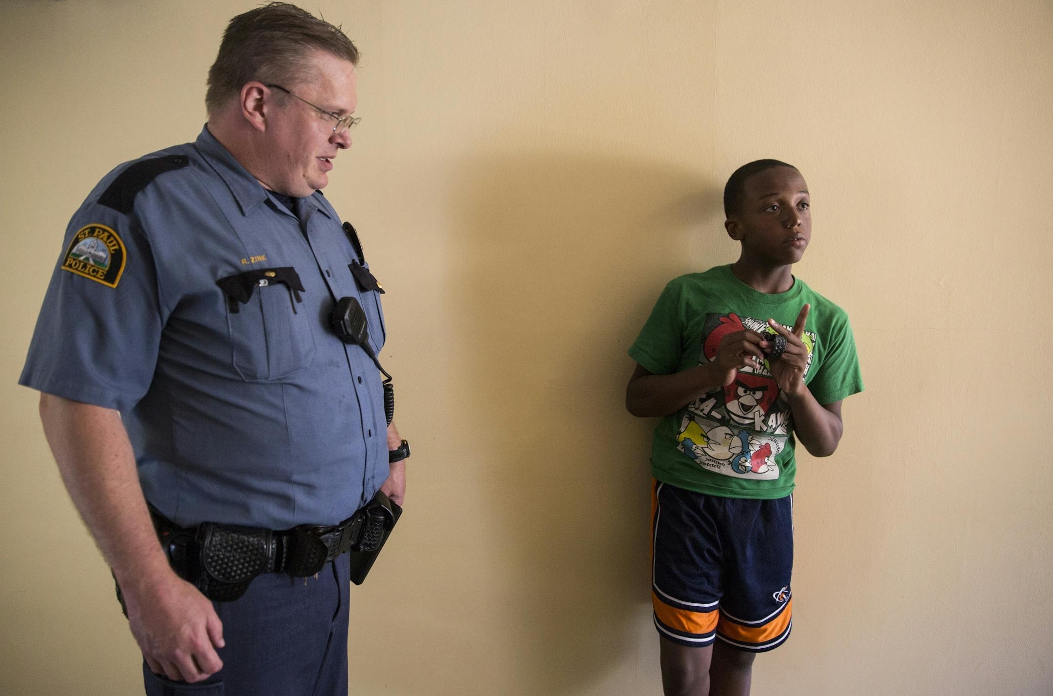 St. Paul Police officer Rob Zink visits with Devont'e Ray-Burns, 12, who has autism and other disabilities, at Ray-Burns' home in St. Paul on Thursday, July 9, 2015.