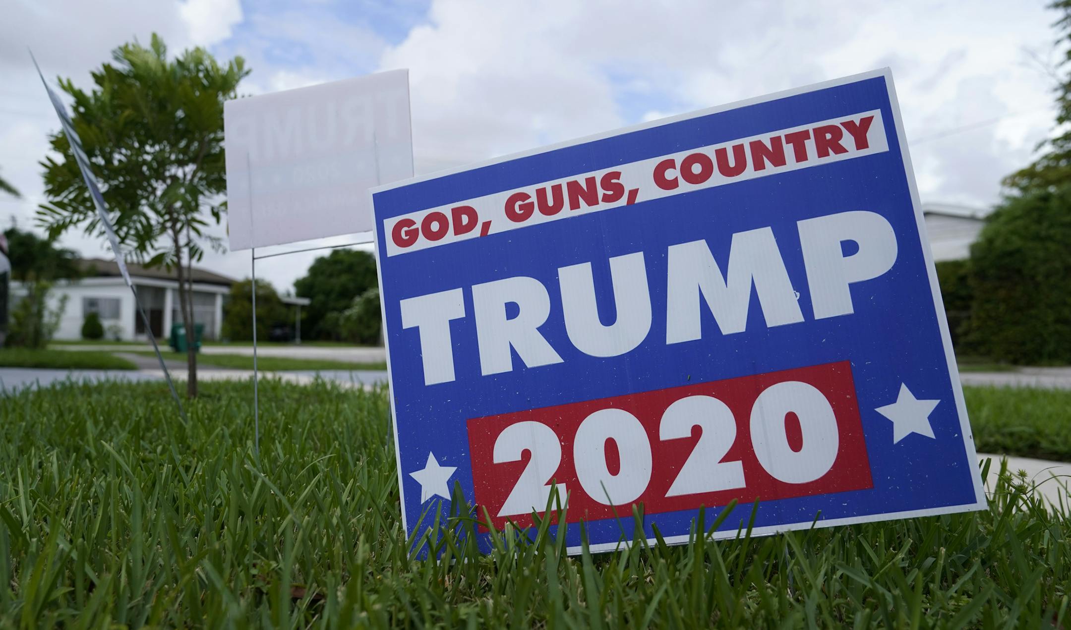 A campaign sign in support of President Donald Trump sits on a lawn Thursday, Oct. 22, 2020, in a Hispanic neighborhood of Miami. Florida's Cuban American voters remain a bright spot in Trump's effort to retain his winning coalition from 2016. Polls show his strong support from these key voters may even be growing to include the younger Cuban Americans that Democrats once considered their best hope of breaking the GOP's hold. (AP Photo/Lynne Sladky)