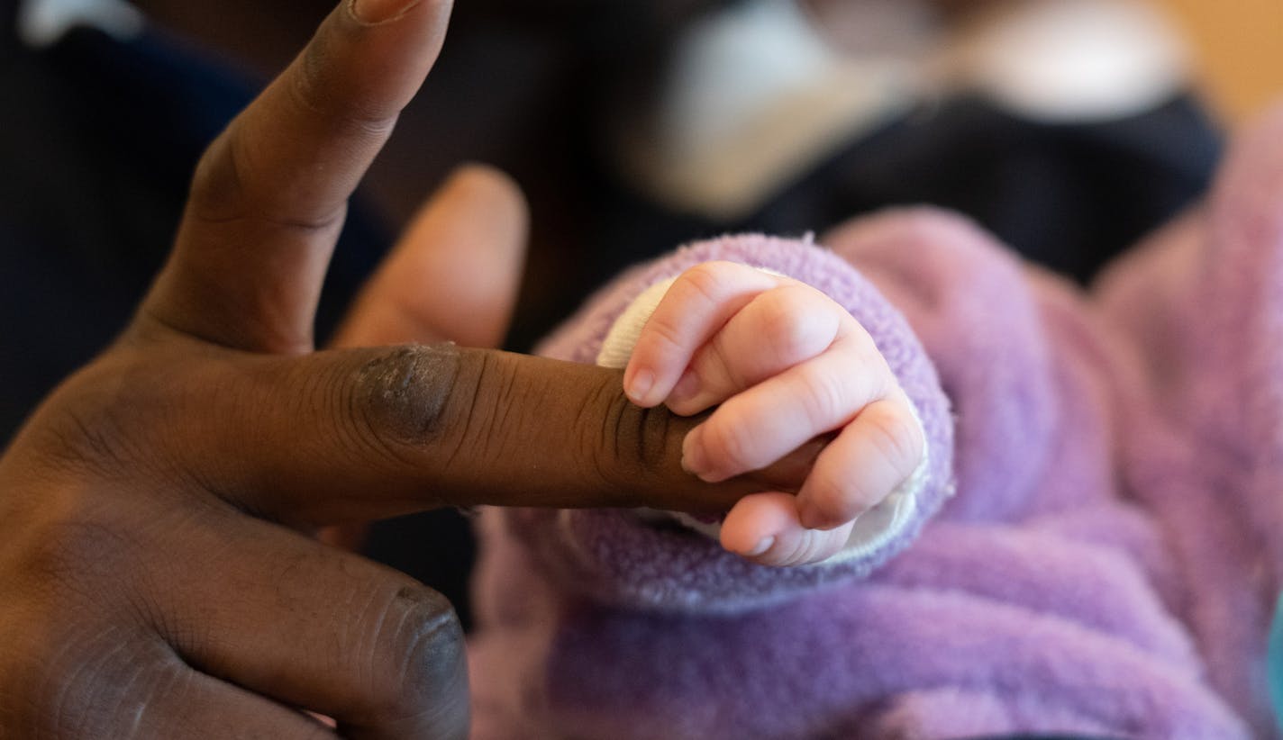 Five-week-old Chanel held her father's finger in her hand. ] MARK VANCLEAVE &#xa5; Jamal Jones and Alliyah Ross (both 20) and their five-week-old daughter Chanel have been staying at Bethlehem Baptist Church with about 100 other former Francis Drake Hotel residents since the Christmas Day fire. Photographed Friday, Dec. 27, 2019 in Minneapolis.