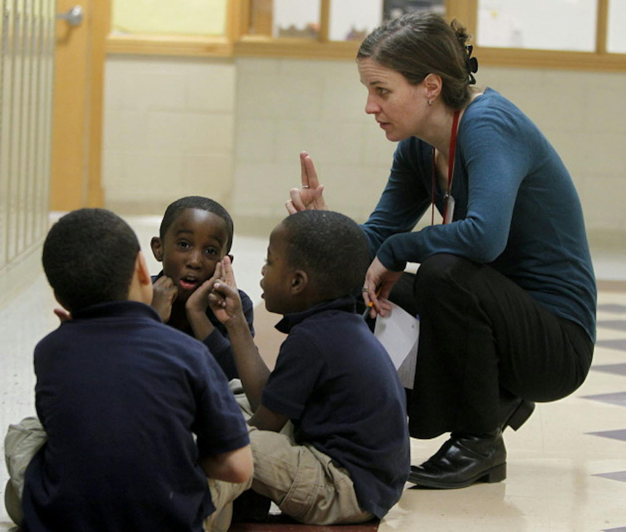 Bottineau Director Tina Maynor teaches students the alphabet in a school hallway.