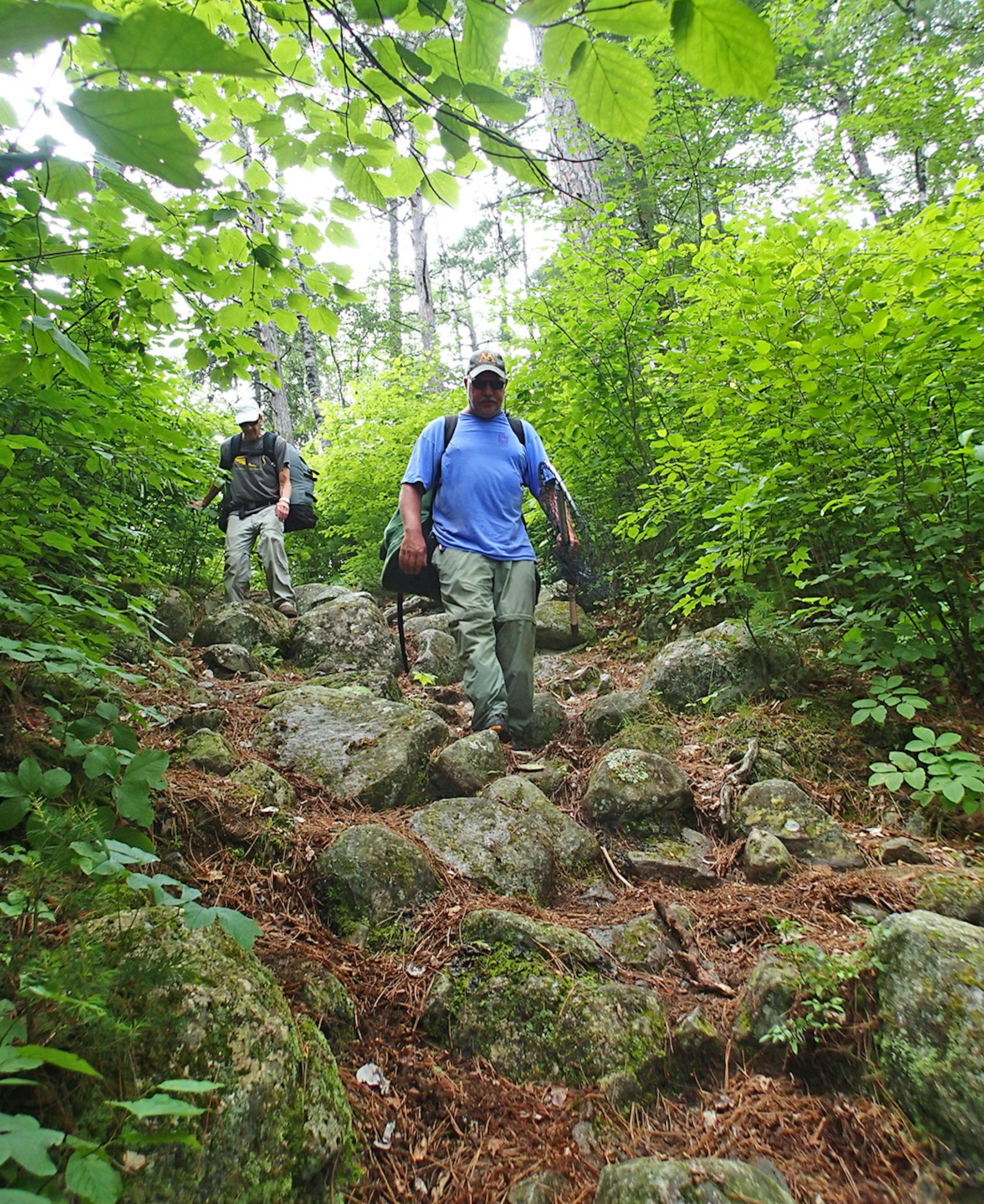 Dave Swenson of Cotton, Minn., and Marv Boerboom of Alexandria, Minn., negotiate a steep, rocky wilderness portage.