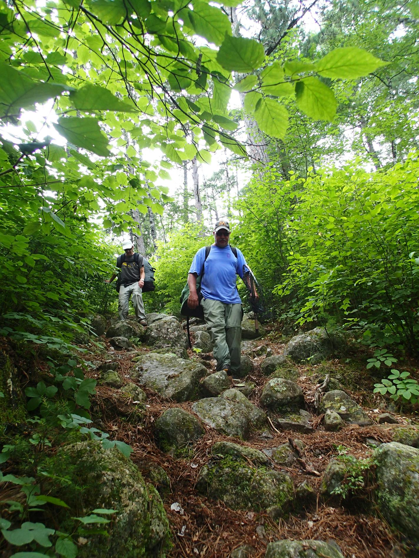 Dave Swenson of Cotton, Minn., and Marv Boerboom of Alexandria, Minn., negotiate a steep, rocky wilderness portage. Star Tribune photo by Doug Smith