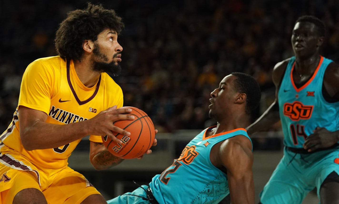 Oklahoma State forward Cameron McGriff (12) went down as Gophers forward Jordan Murphy (3) collided into him before taking a shot in the first half.