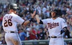 Minnesota Twins' Max Kepler (26) and teammate Brian Dozier celebrate after scoring against the Milwaukee Brewers in the eighth inning of a baseball ga