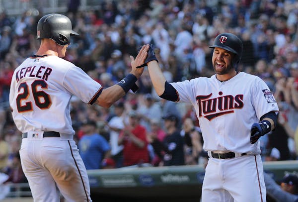 Minnesota Twins' Max Kepler (26) and teammate Brian Dozier celebrate after scoring against the Milwaukee Brewers in the eighth inning of a baseball ga