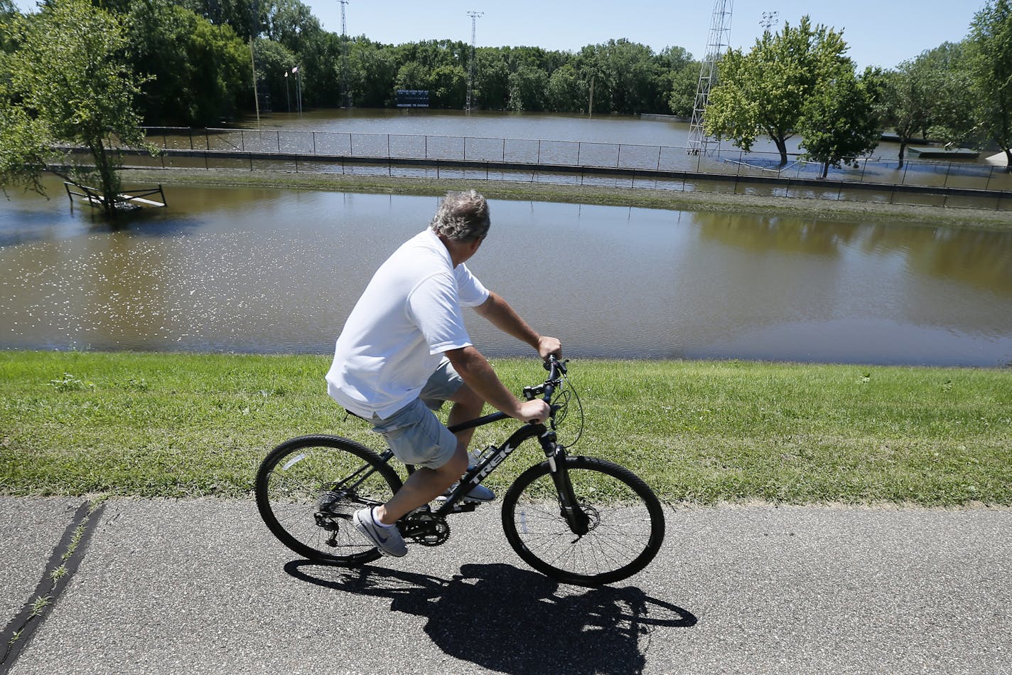 A cyclist looked at the flood Athletics Park home of the Chaska Cubs baseball team Sunday June 29, 2014 in Chaska, MN. ] Jerry Holt Jerry.holt@startribune.com