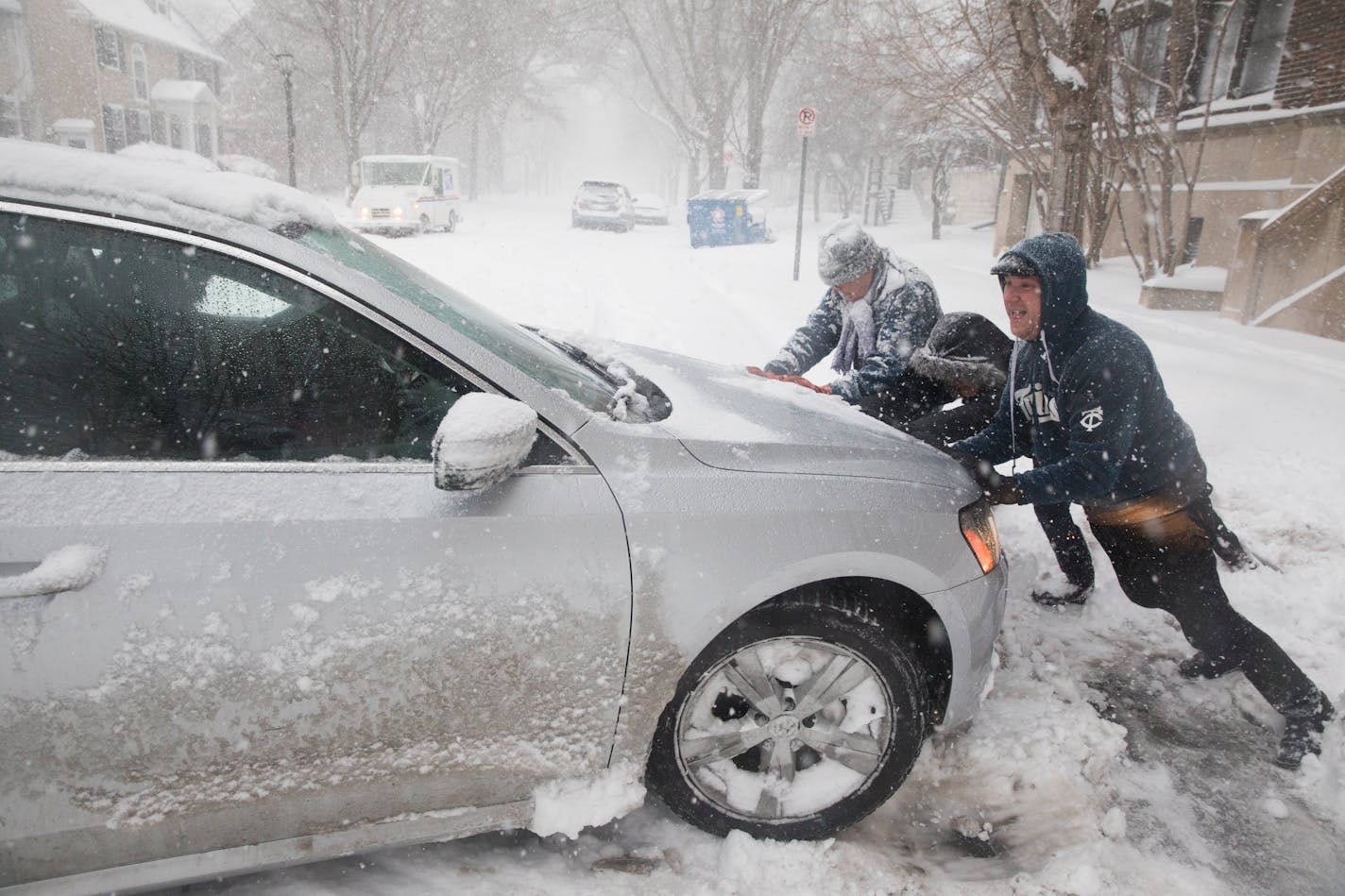 David Maruska gets help pushing his wife's car out of the snow.