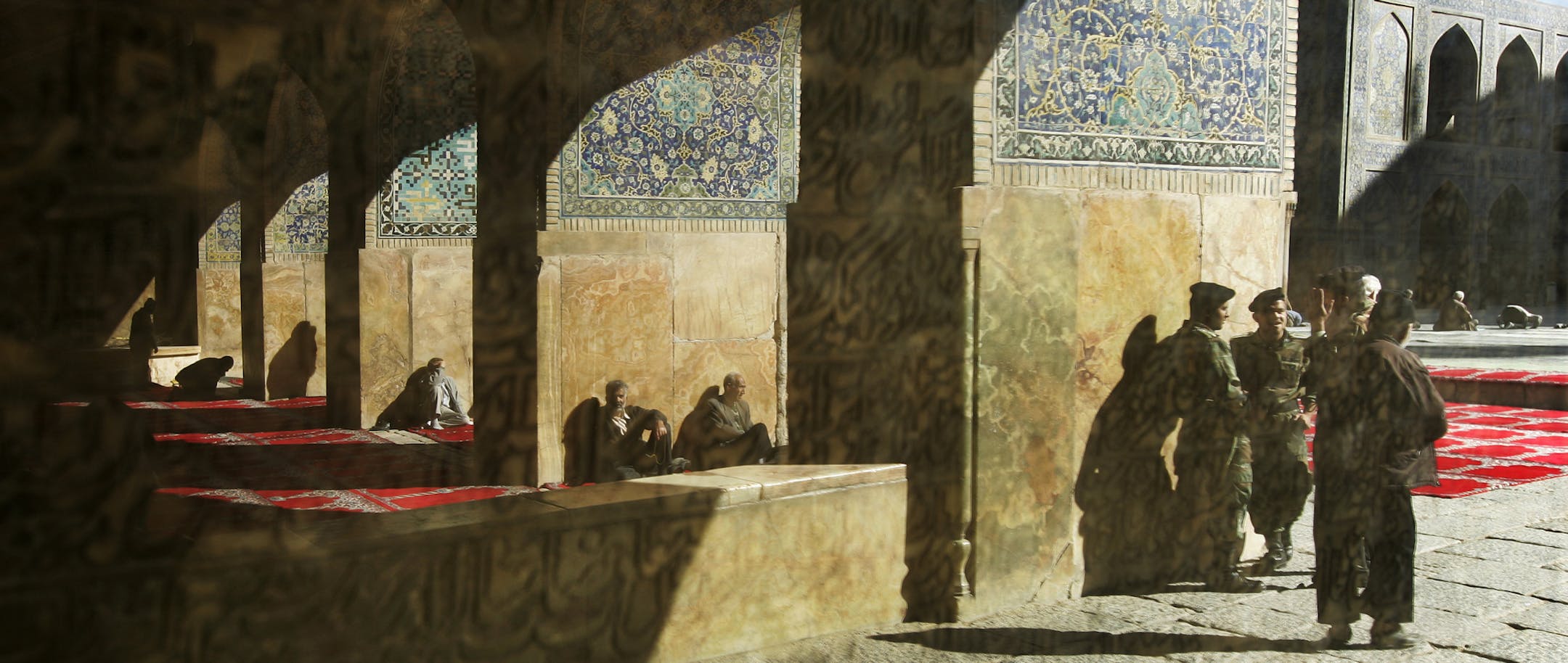 Iranian army soldiers providing security, right, are seen reflected in a stone tablet inscribed with Quranic verses, during traditional Muslim Friday prayers at the Imam mosque in Isfahan, Iran, Friday, Nov. 30, 2007. The Imam mosque was constructed by Shah Abbas I in the early 17th Century A.D. during the Safavid empire, which saw a great flourishing of Persian art and architecture. (AP Photo/Ben Curtis) ORG XMIT: ABC101