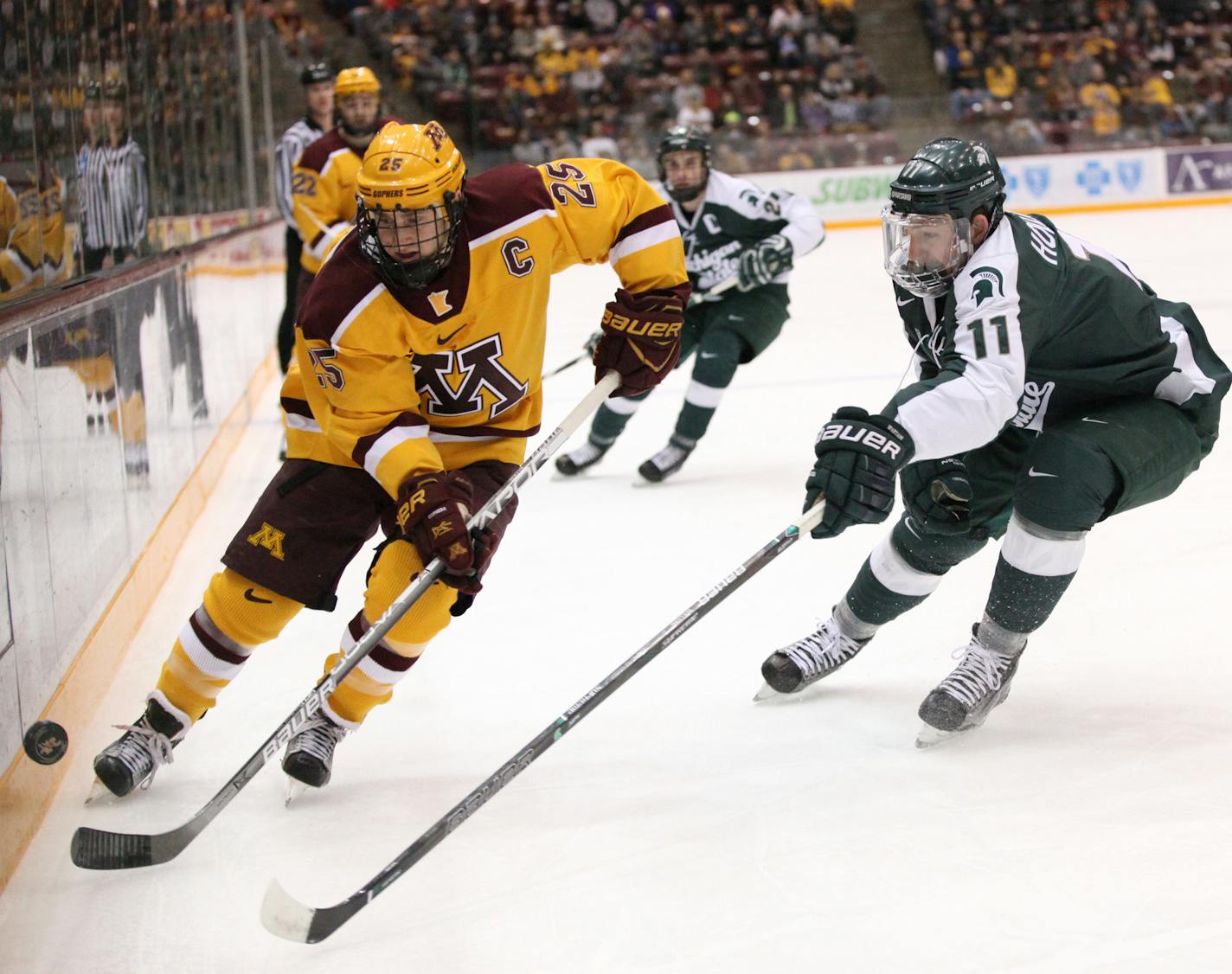 Minnesota Gophers&#x2019; Justin Kloos (25) and Michigan State Spartans&#x2019; Rhett Holland (11) chase the puck in the first period. ] XAVIER WANG &#x2022; xavier.wang@startribune.com Game action from a Big Ten Men&#x2019;s hockey game between Minnesota Gophers and Michigan State Spartans on Saturday. March, 11. 2017. at Mariucci Arena on the grounds of University of Minnesota in Minneapolis.