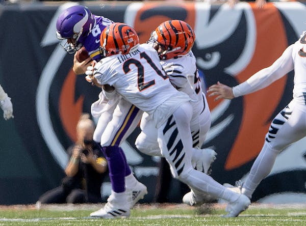 Vikings quarterback Kirk Cousins (8) was sacked by Mike Hilton (21) and B.J. Hill (92) of the Cincinnati Bengals in the fourth quarter.