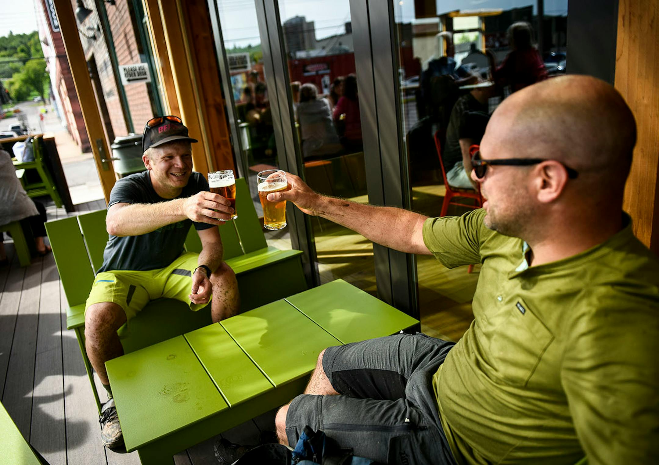 Frank Lundeen, of West Duluth, left, and David Gabrys, of Minneapolis, toasted their upcoming 3-day bikepacking trip to Two Harbors while drinking beers on Bent Paddle Brewing Company's new patio Thursday.