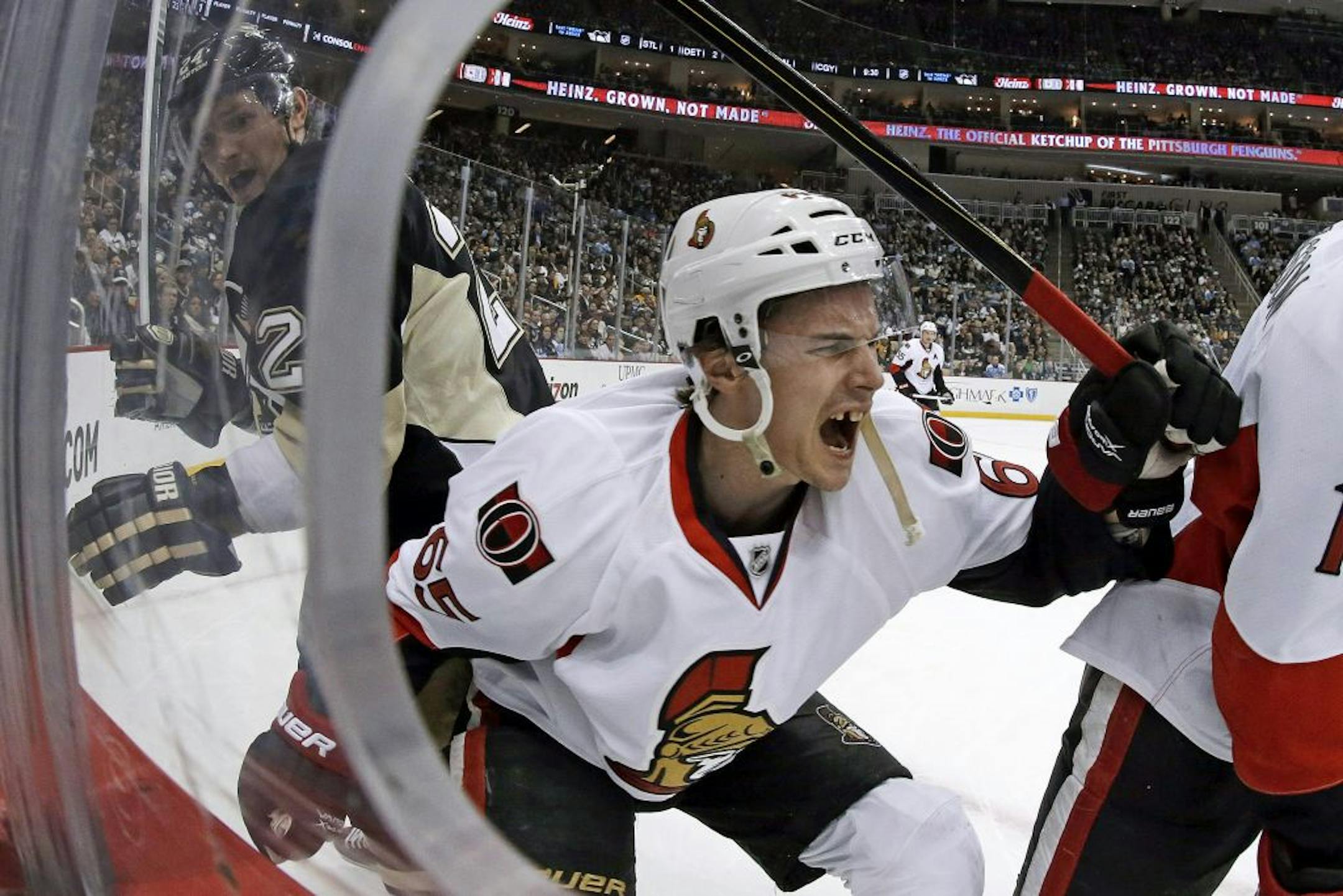 Ottawa Senators defenseman Erik Karlsson grimaces after he was cut by Penguins left wing Matt Cooke.