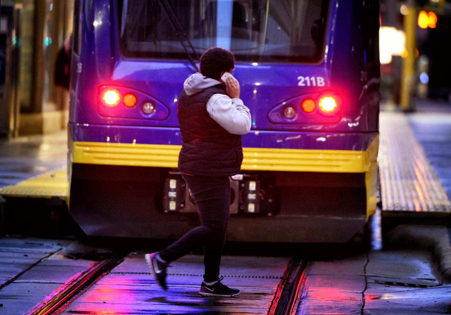 Another pedestrian used her phone while crossing in front of a light-rail train.