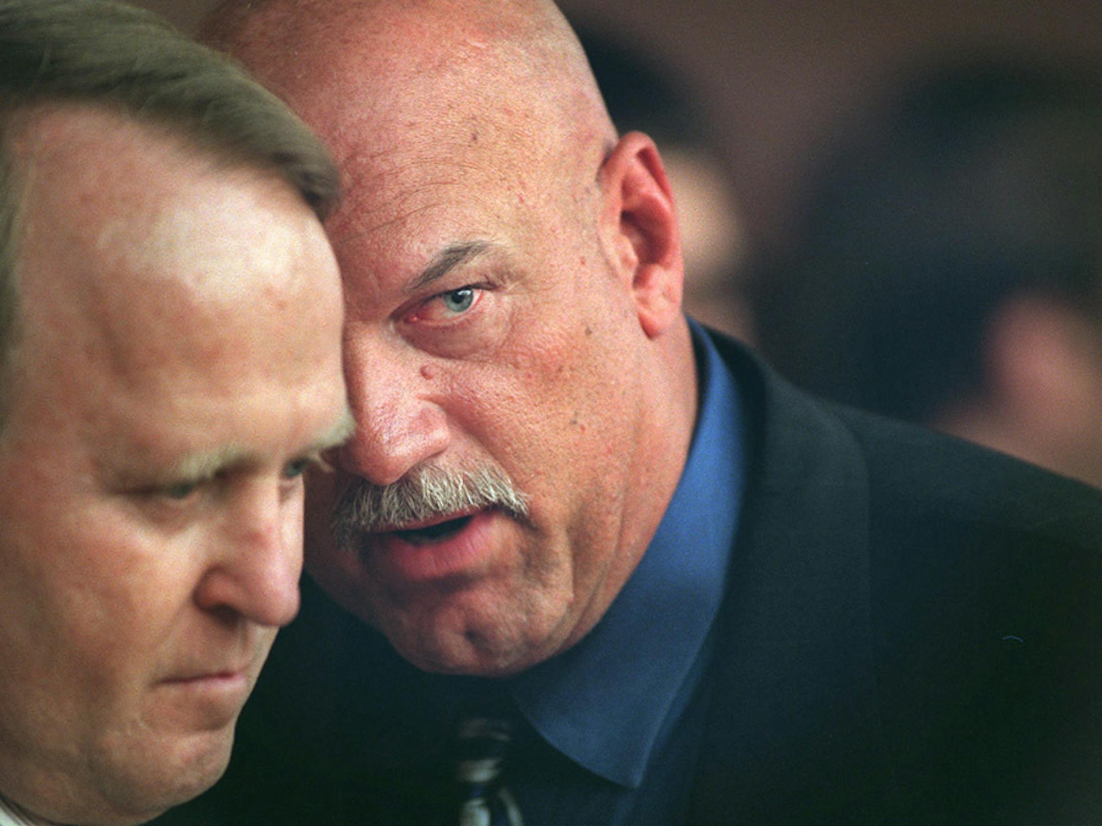 Gov. Jesse Ventura speaks with Dean Barkley before testifying before a joint House-Senate unicameral hearing in St. Paul Monday night.